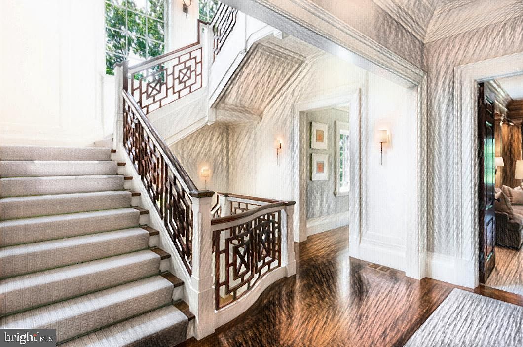 A stair hall with a custom wood fretwork railing and hardwood floors in a completed Polo Design Build home